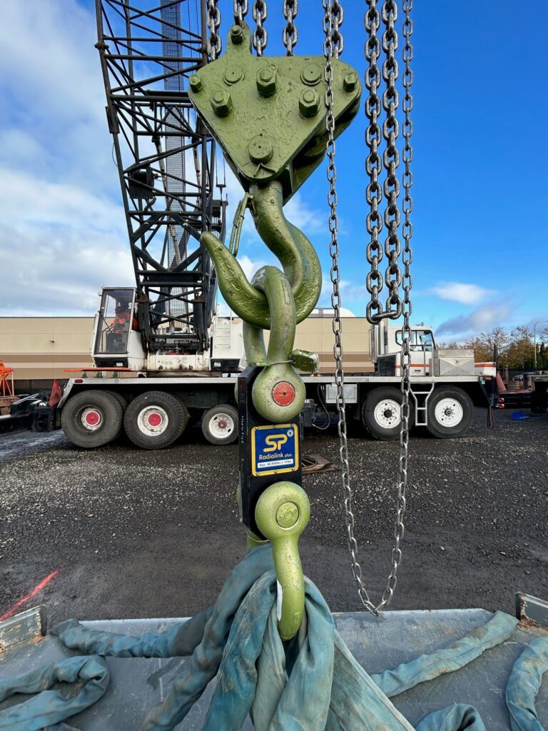 A digital load link rental from LGH, also known as a crane load cell, testing the weight of a load on a jobsite.