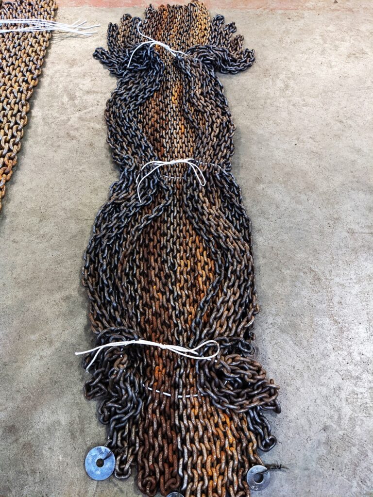 A photo of a bundle of chain, laid out on the floor inside an LGH warehouse
